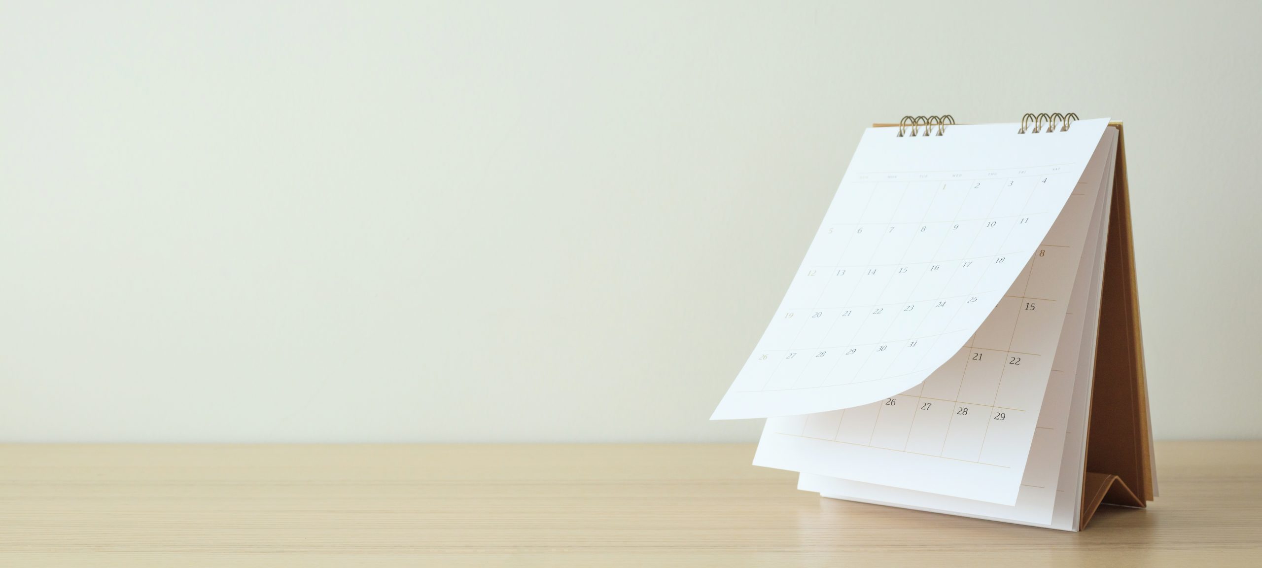 Calendrier papier sur fond uni et comptoir de bois pâle